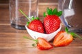 Red strawberries whole and sliced Ã¢â¬â¹Ã¢â¬â¹half and glass cup and jar Royalty Free Stock Photo